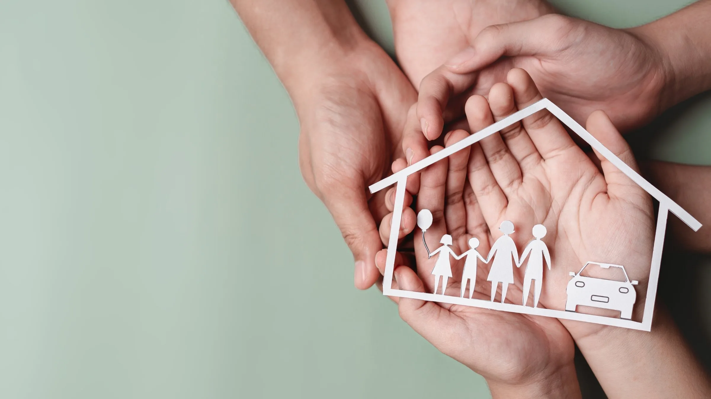 hands holding a wooden home diorama