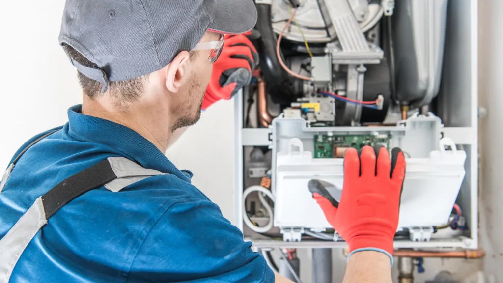 A repairman working on a furnace repair in Sacramento.