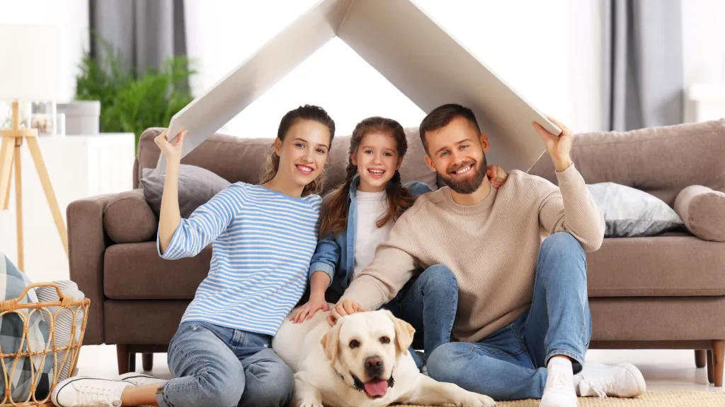 A happy family sitting on the floor of their living room after an HVAC repair in Sacramento.