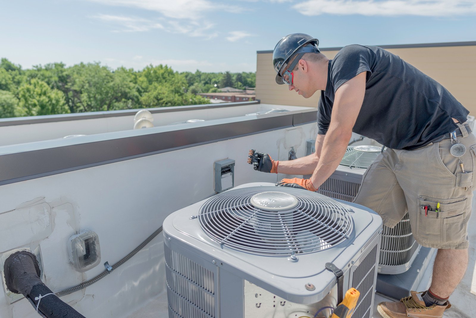 an elite heating and air hvac service technician performing hvac maintenance on a unit